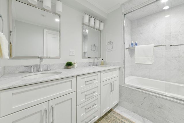 a bathroom with a sink double vanity granite tub shower and a mirror