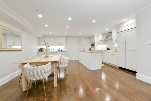 a kitchen with a dining table chairs and white stainless steel appliances