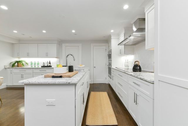 a kitchen with granite countertop kitchen island a sink stainless steel appliances and cabinets