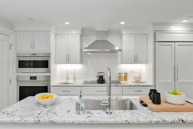 a kitchen with stainless steel appliances granite countertop a sink and a stove