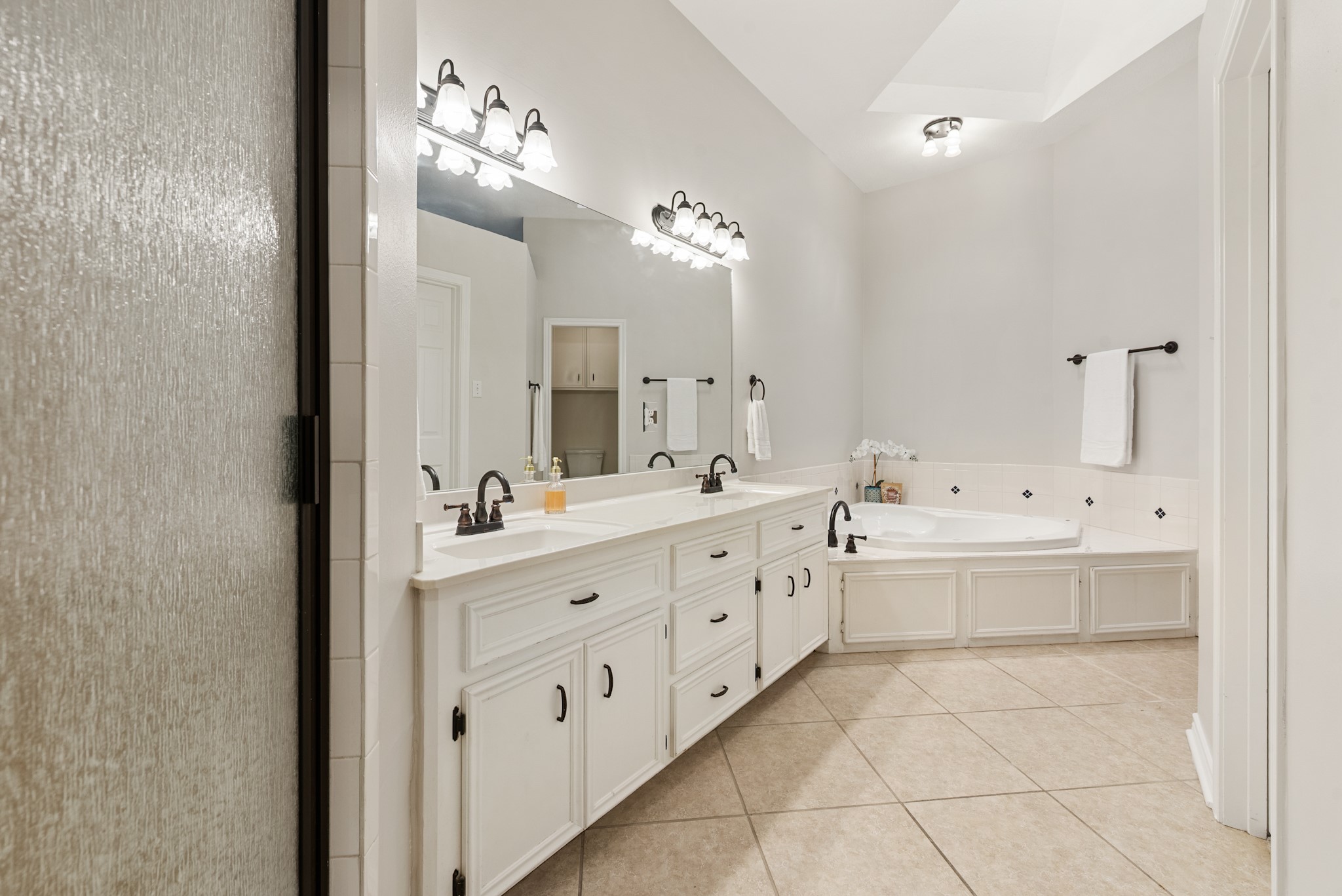 4505 Kensington Road Bryan, TX 77802 - Photo 16 of 26 En suite primary bathroom with oversized corner jetted tub, separate shower, large walk in closet with built in shelving. Dual sinks, tons of counter space