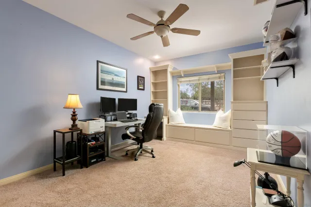 a view of a workspace with furniture and a window