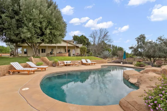 a view of a swimming pool with lounge chairs in patio