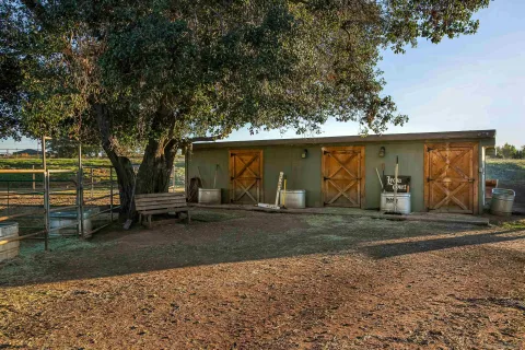 a view of a backyard with lawn chairs and a fire pit