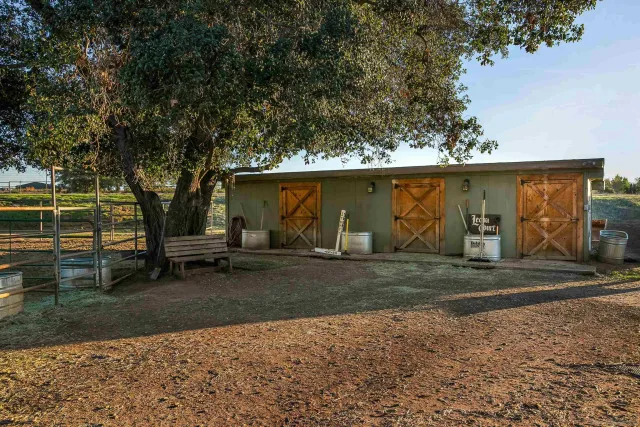 a view of a backyard with lawn chairs and a fire pit
