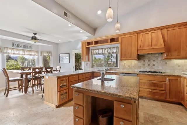 a large kitchen with lots of counter space dining table and stainless steel appliances