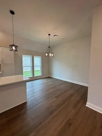 a view of a room with wooden floor and windows