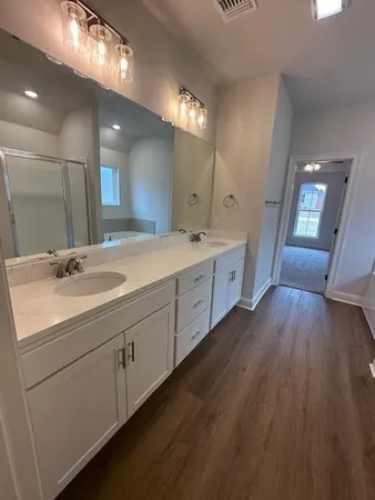 a spacious bathroom with a double vanity sink and mirror