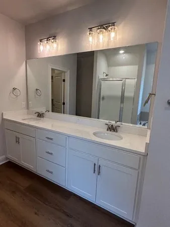 a bathroom with double vanity and a mirror