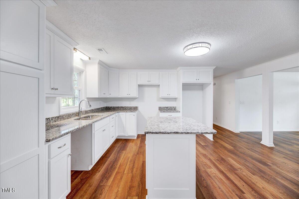 103 Allendale Road Four Oaks, NC 27524 - Photo 11 of 44 a large kitchen with cabinets wooden floor and stainless steel appliances