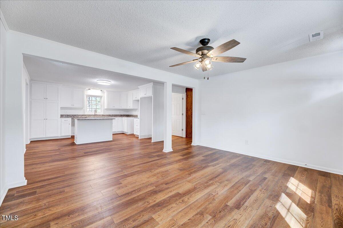 103 Allendale Road Four Oaks, NC 27524 - Photo 16 of 44 a view of empty room with wooden floor and fan