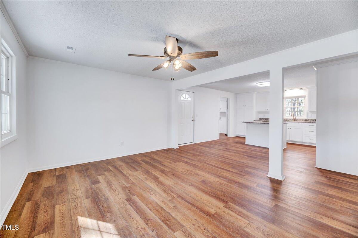 103 Allendale Road Four Oaks, NC 27524 - Photo 17 of 44 a view of empty room with wooden floor and fan