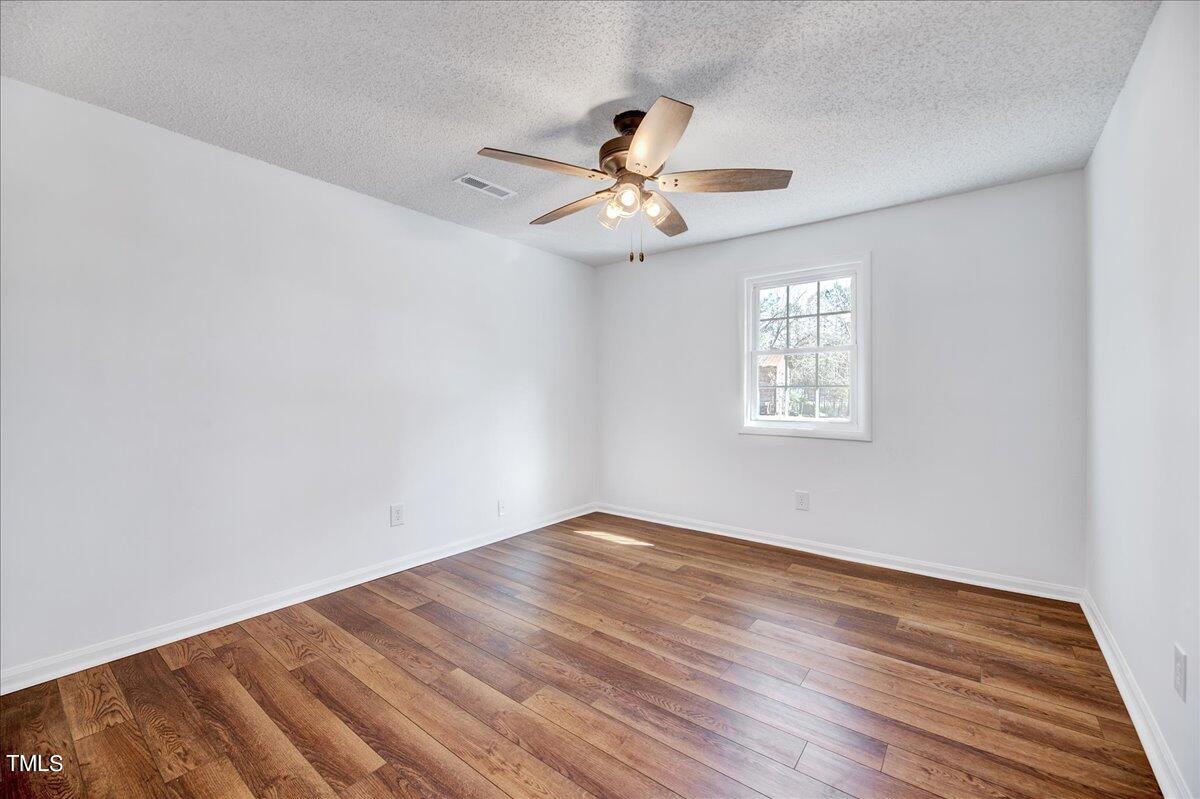 103 Allendale Road Four Oaks, NC 27524 - Photo 26 of 44 an empty room with wooden floor a ceiling fan and windows