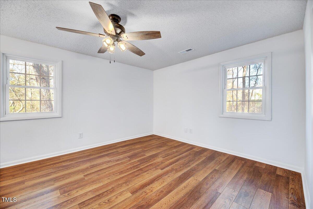 103 Allendale Road Four Oaks, NC 27524 - Photo 28 of 44 a view of empty room with wooden floor and fan