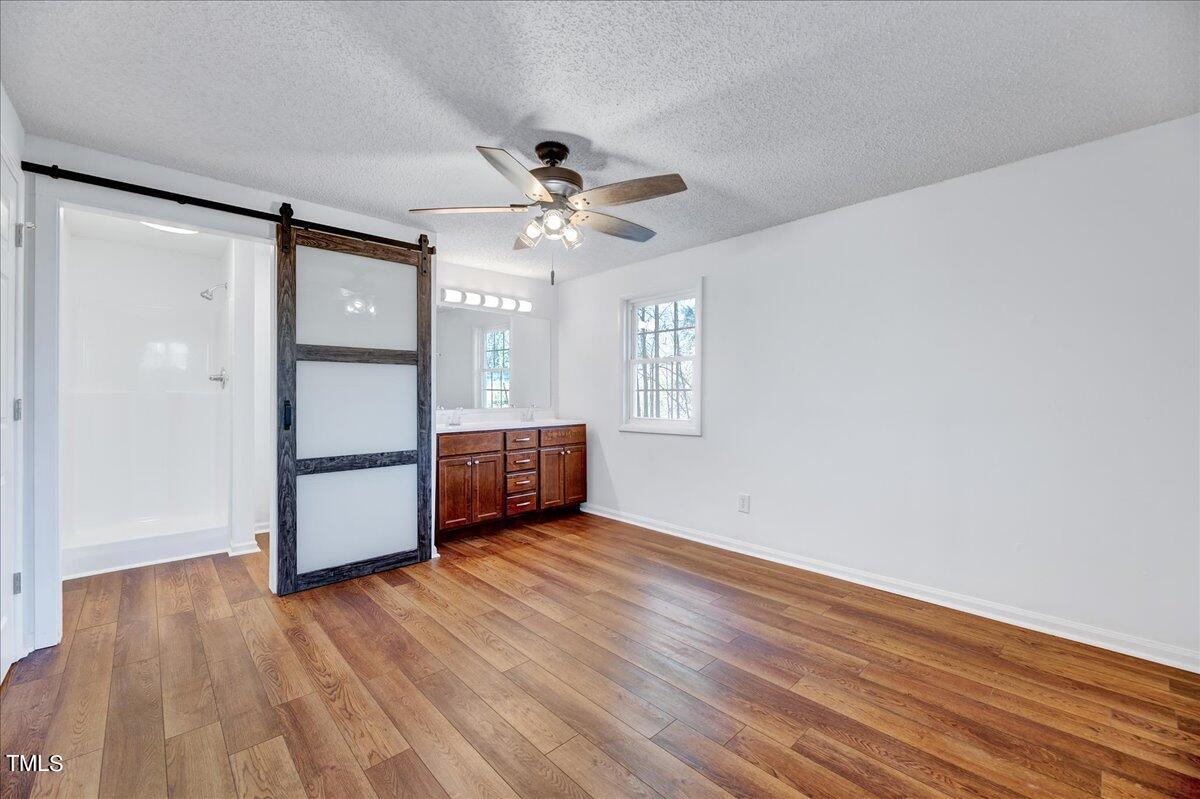 103 Allendale Road Four Oaks, NC 27524 - Photo 29 of 44 a view of a livingroom with wooden floor and a ceiling fan