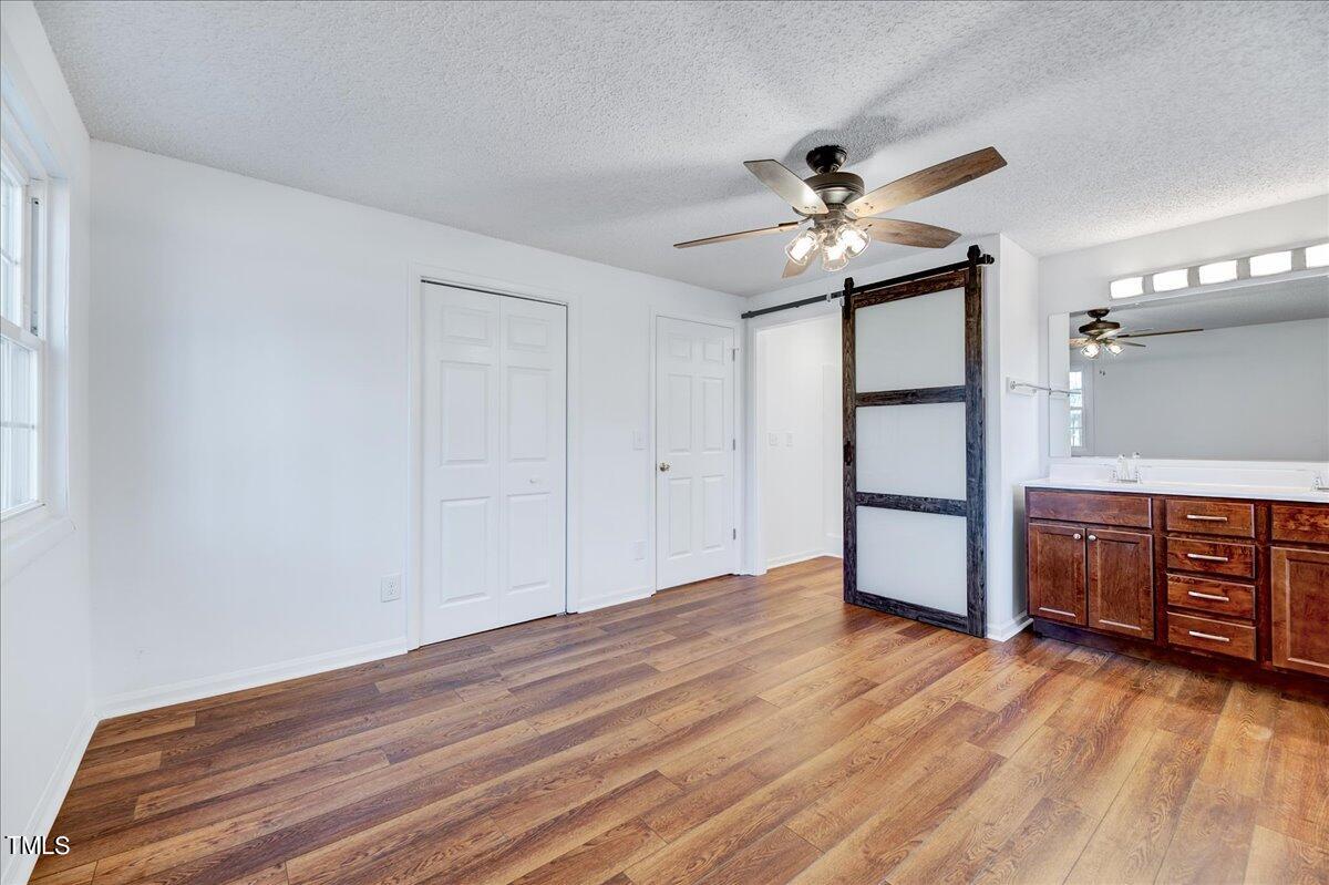103 Allendale Road Four Oaks, NC 27524 - Photo 31 of 44 a view of a livingroom with wooden floor and a ceiling fan