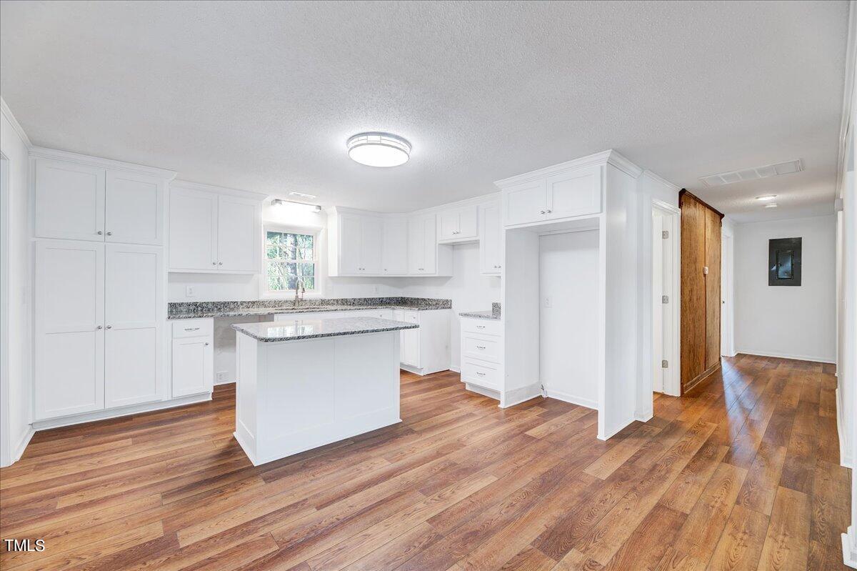 103 Allendale Road Four Oaks, NC 27524 - Photo 8 of 44 a kitchen with wooden floors and white cabinets