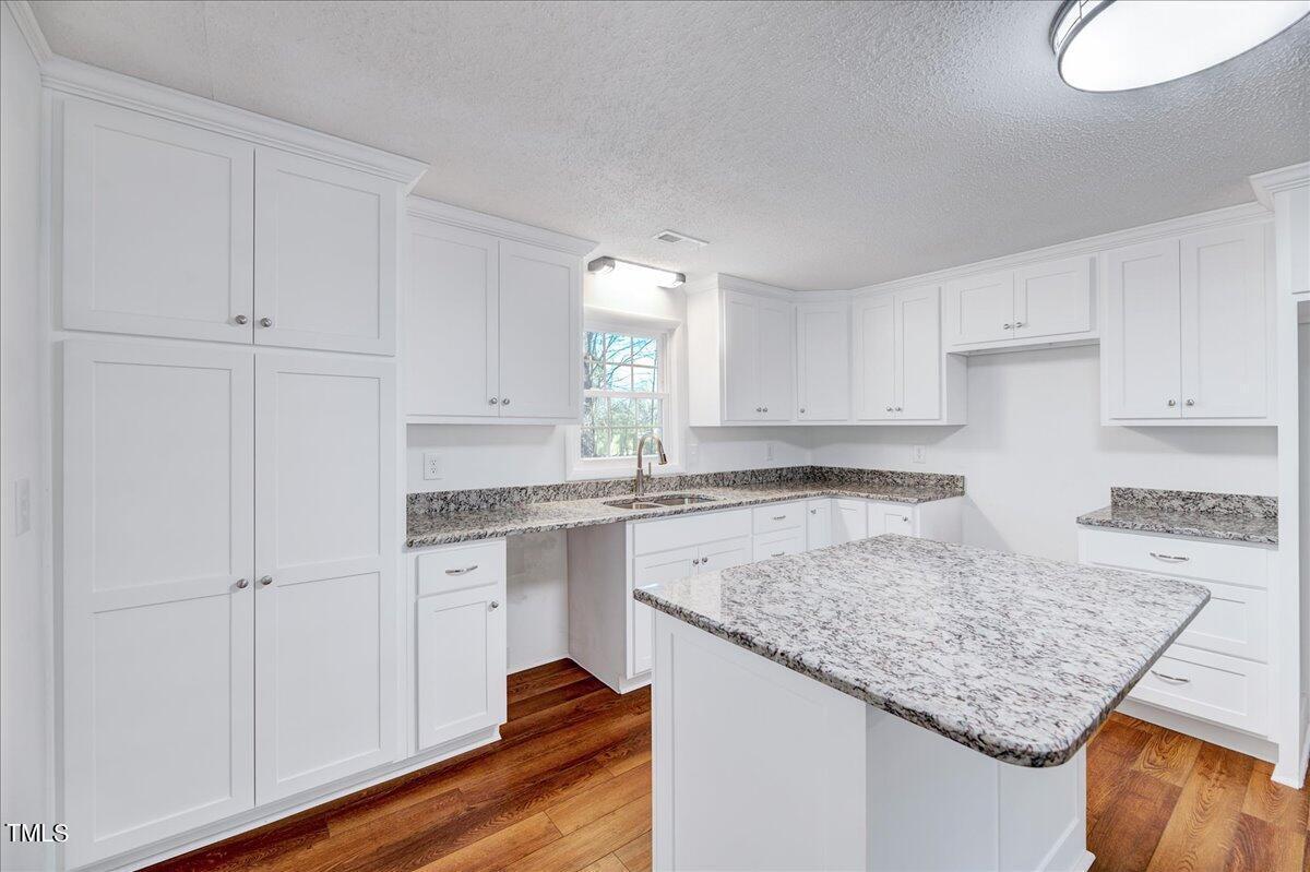 103 Allendale Road Four Oaks, NC 27524 - Photo 9 of 44 a kitchen with granite countertop white cabinets and a sink