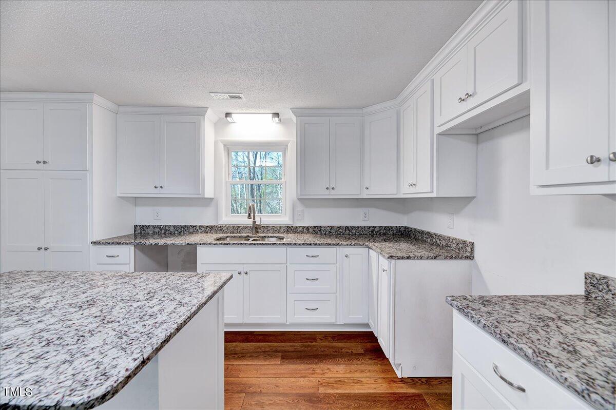 103 Allendale Road Four Oaks, NC 27524 - Photo 10 of 44 a kitchen with granite countertop a sink a stove and cabinets