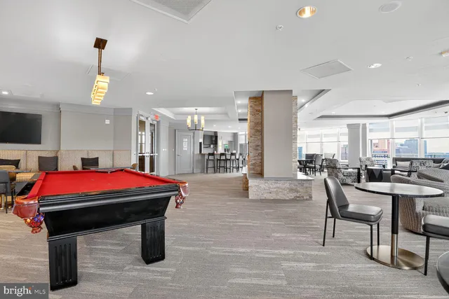 a living room with furniture a table and kitchen view