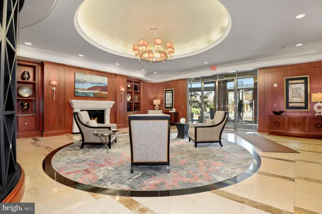 a dining room with wooden floor a chandelier a glass table and chairs