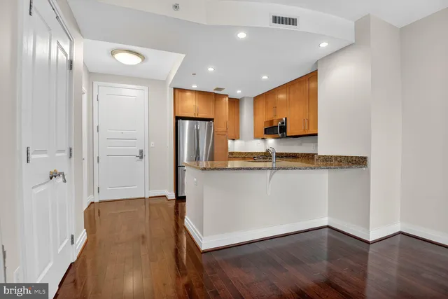 a view of kitchen with stainless steel appliances granite countertop refrigerator sink and stove