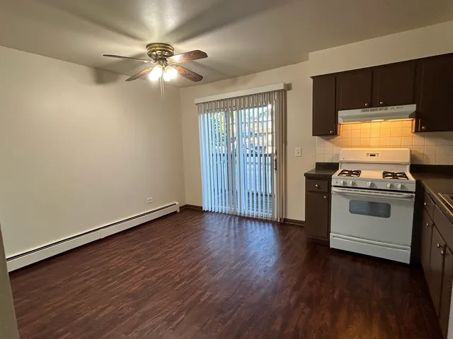 a view of kitchen with stove cabinets and wooden floor