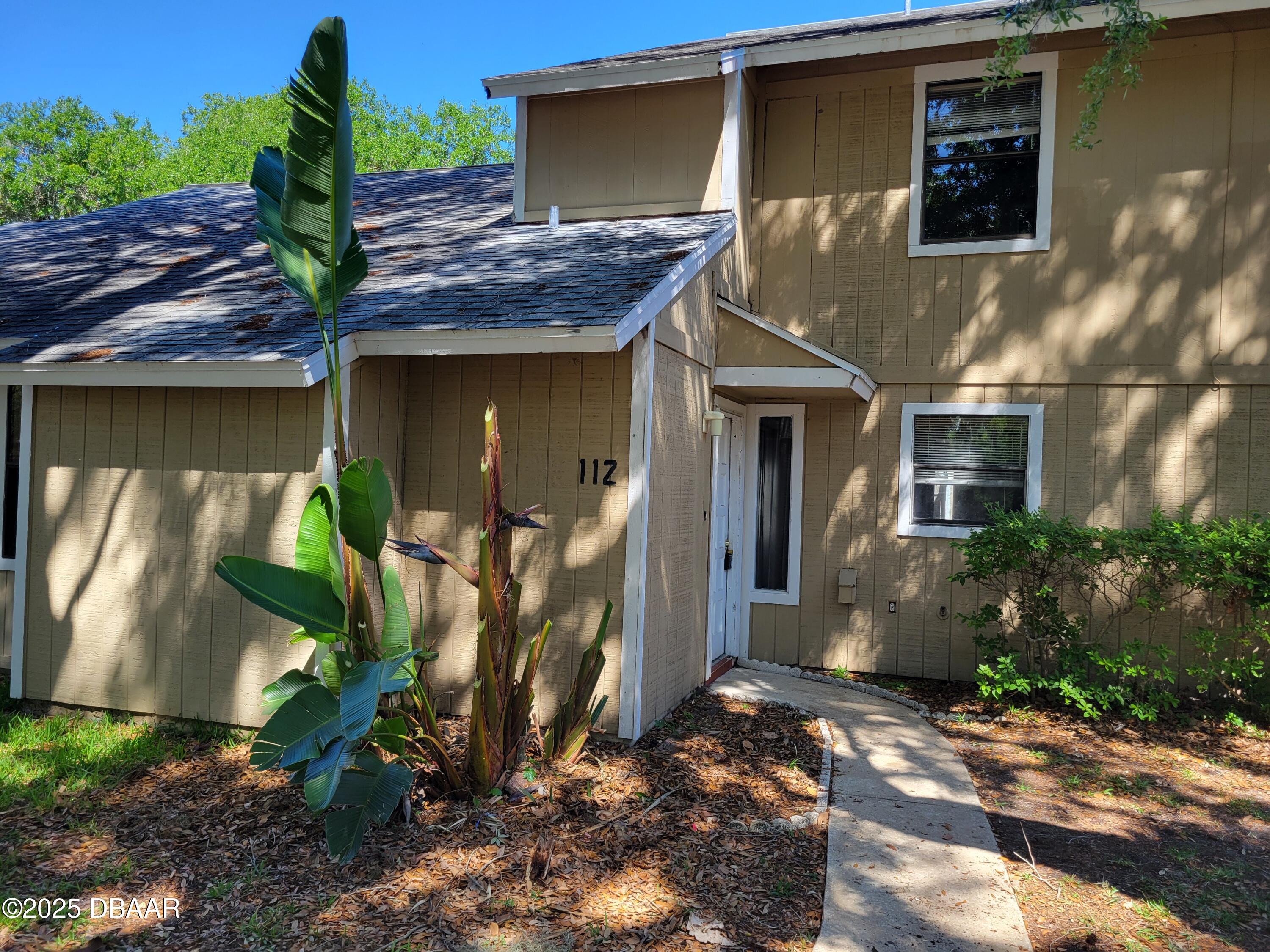 a view of a house with plants next to yard