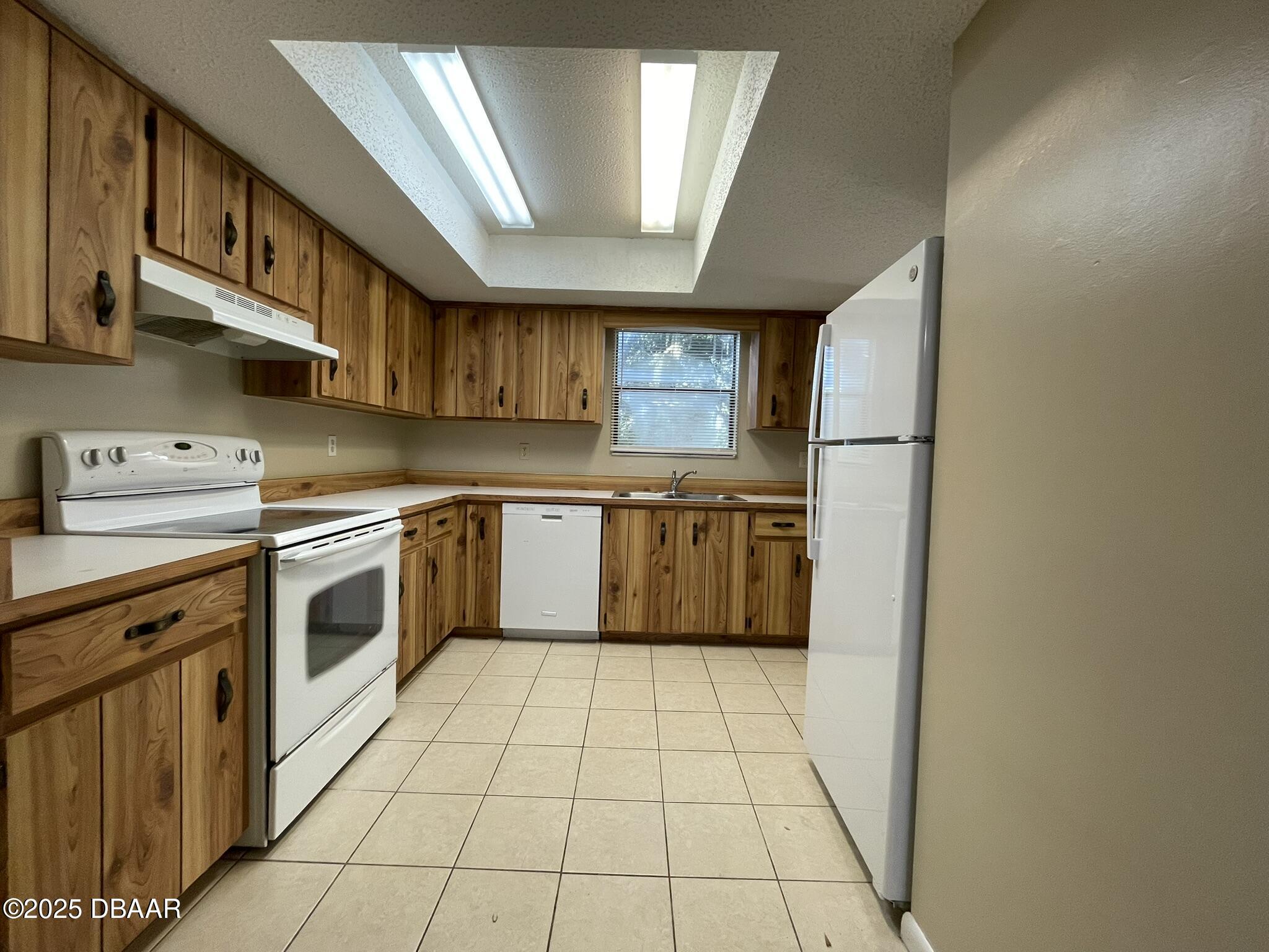 112 Tomoka Meadows Boulevard Ormond Beach, FL 32174 - Photo 3 of 53 a kitchen with a stove top oven sink and cabinets