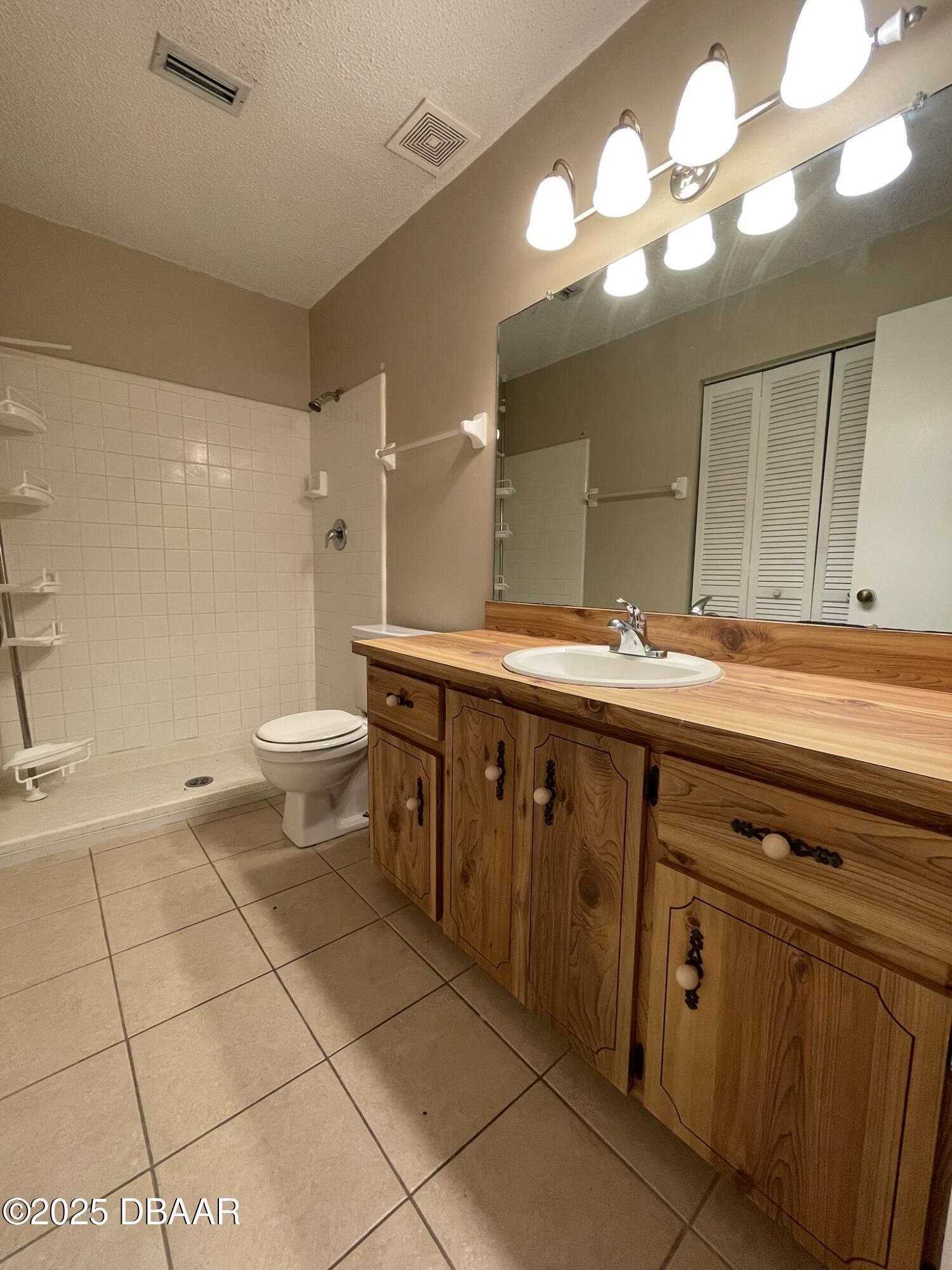112 Tomoka Meadows Boulevard Ormond Beach, FL 32174 - Photo 35 of 53 a spacious bathroom with a granite countertop sink a toilet and a mirror