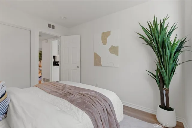 a bedroom with a large bed and a potted plant