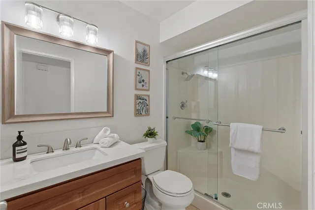 a bathroom with a granite countertop sink a toilet and a mirror