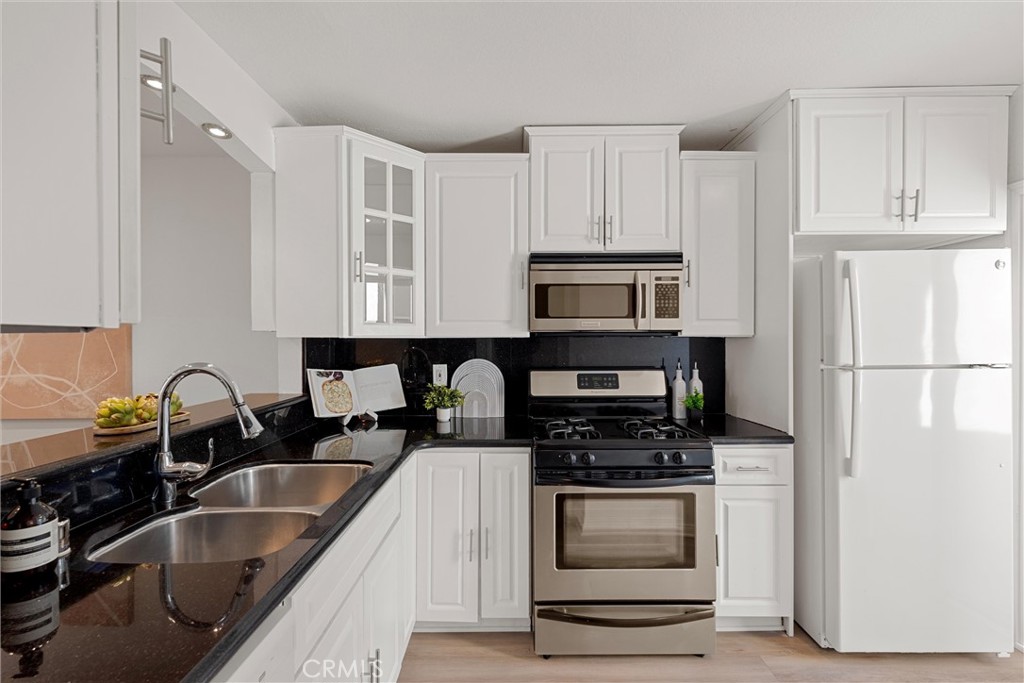 32 Kazan Street Irvine, CA 92604 - Photo 19 of 39 a kitchen with granite countertop a sink stainless steel appliances and white cabinets