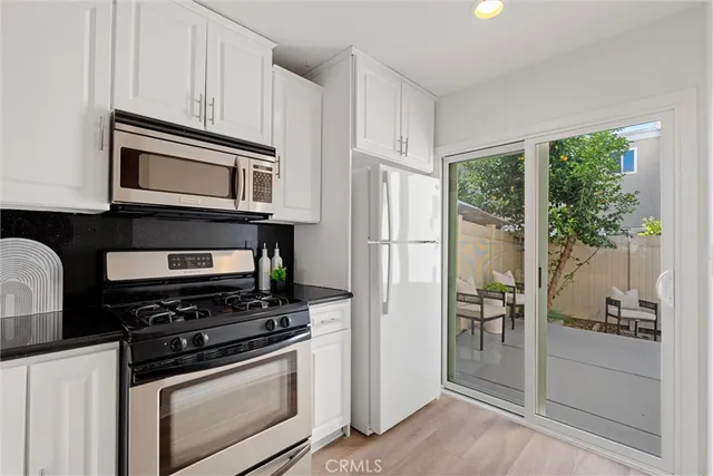 a kitchen with stainless steel appliances granite countertop a stove microwave and refrigerator