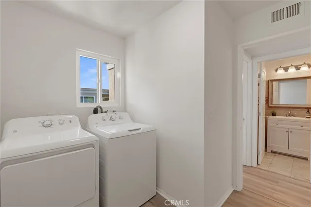a view of washer and dryer with bathroom in the background