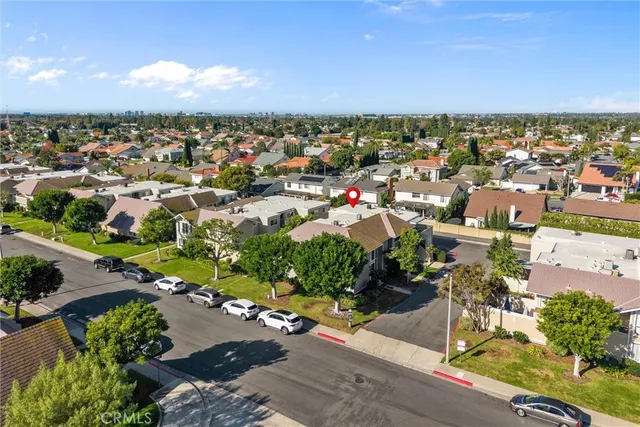 an aerial view of a city with lots of residential buildings ocean and mountain view in back