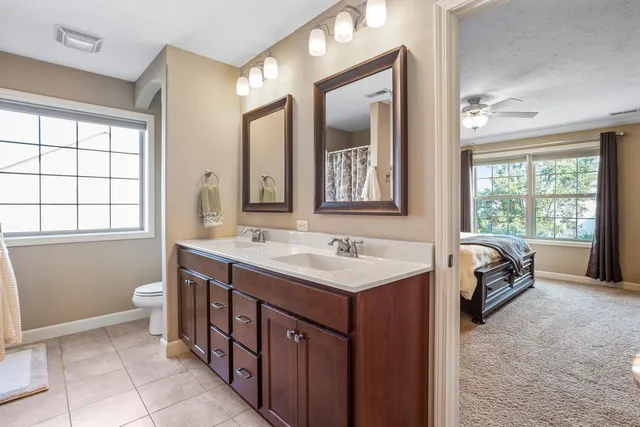 a spacious bathroom with a double vanity sink a mirror and a bathtub