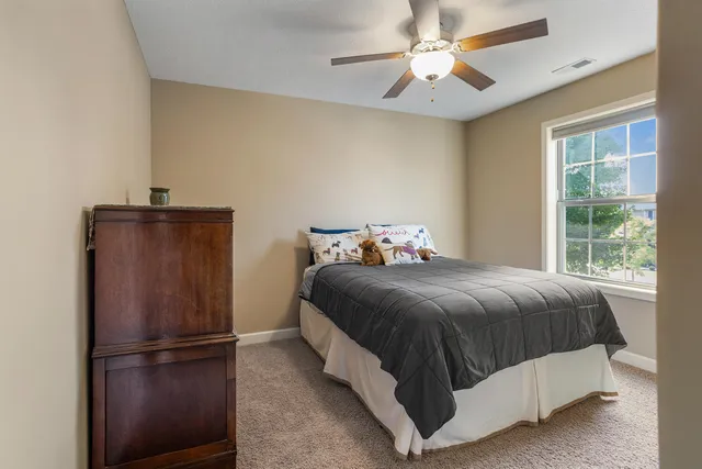 a bedroom with a bed and a ceiling fan