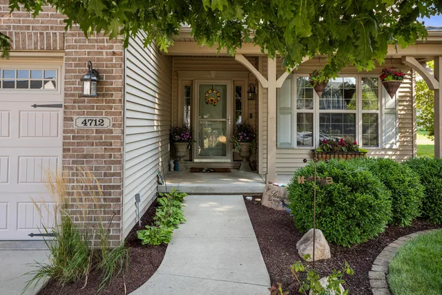 a view of a house with a small yard and potted plants