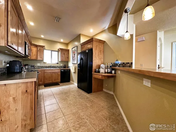 a kitchen with stainless steel appliances granite countertop a refrigerator a stove and a sink