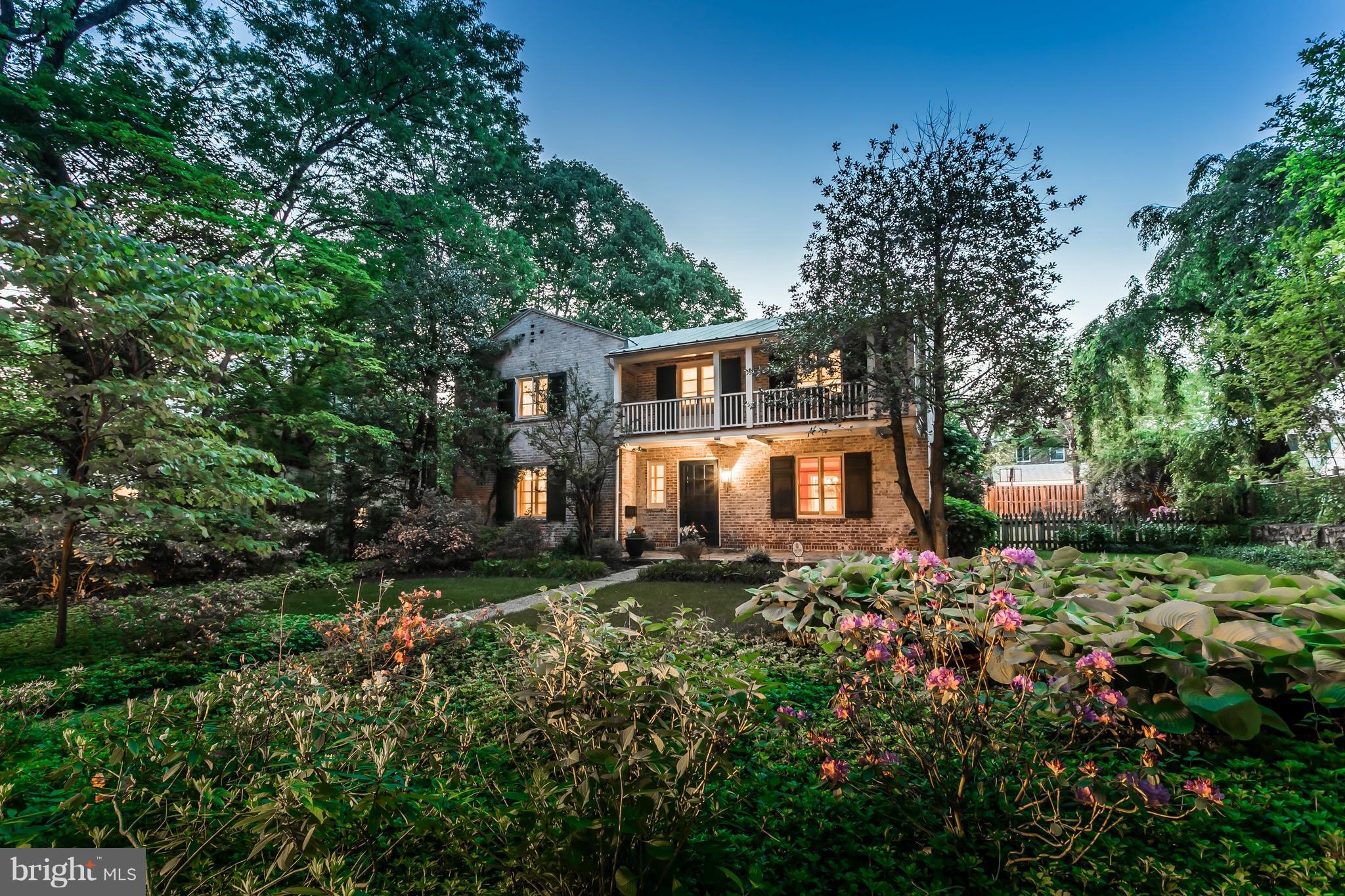 a front view of a house with yard and trees