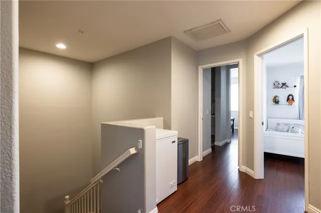 a view of a hallway with wooden floor and furniture