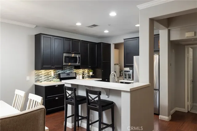 a kitchen with granite countertop wooden cabinets and stainless steel appliances
