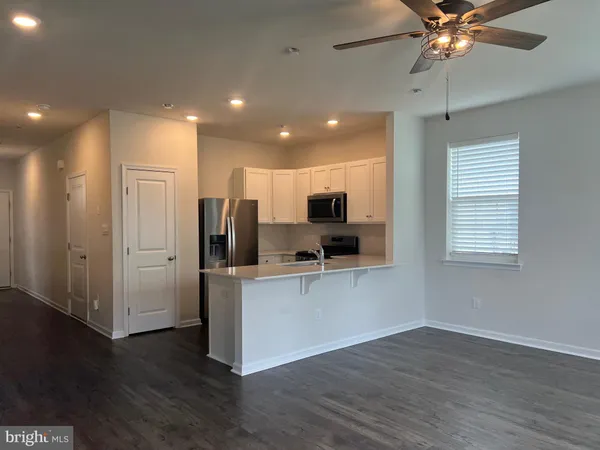 a view of kitchen with stainless steel appliances refrigerator stove microwave and cabinets