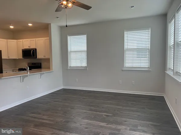 a view of kitchen with stainless steel appliances granite countertop a refrigerator a sink a stove and microwave with wooden floor