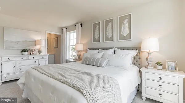 a bedroom with a bed a lamp and dresser with mirror