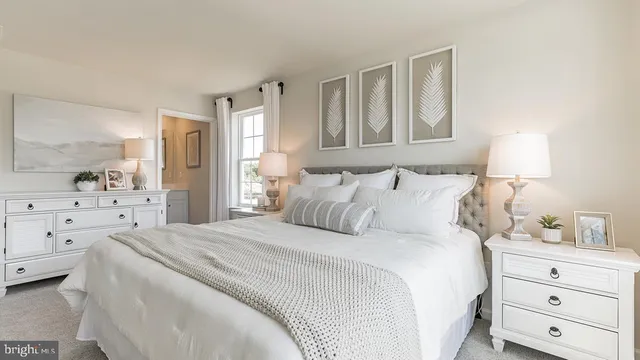 a bedroom with a bed a lamp and dresser with mirror