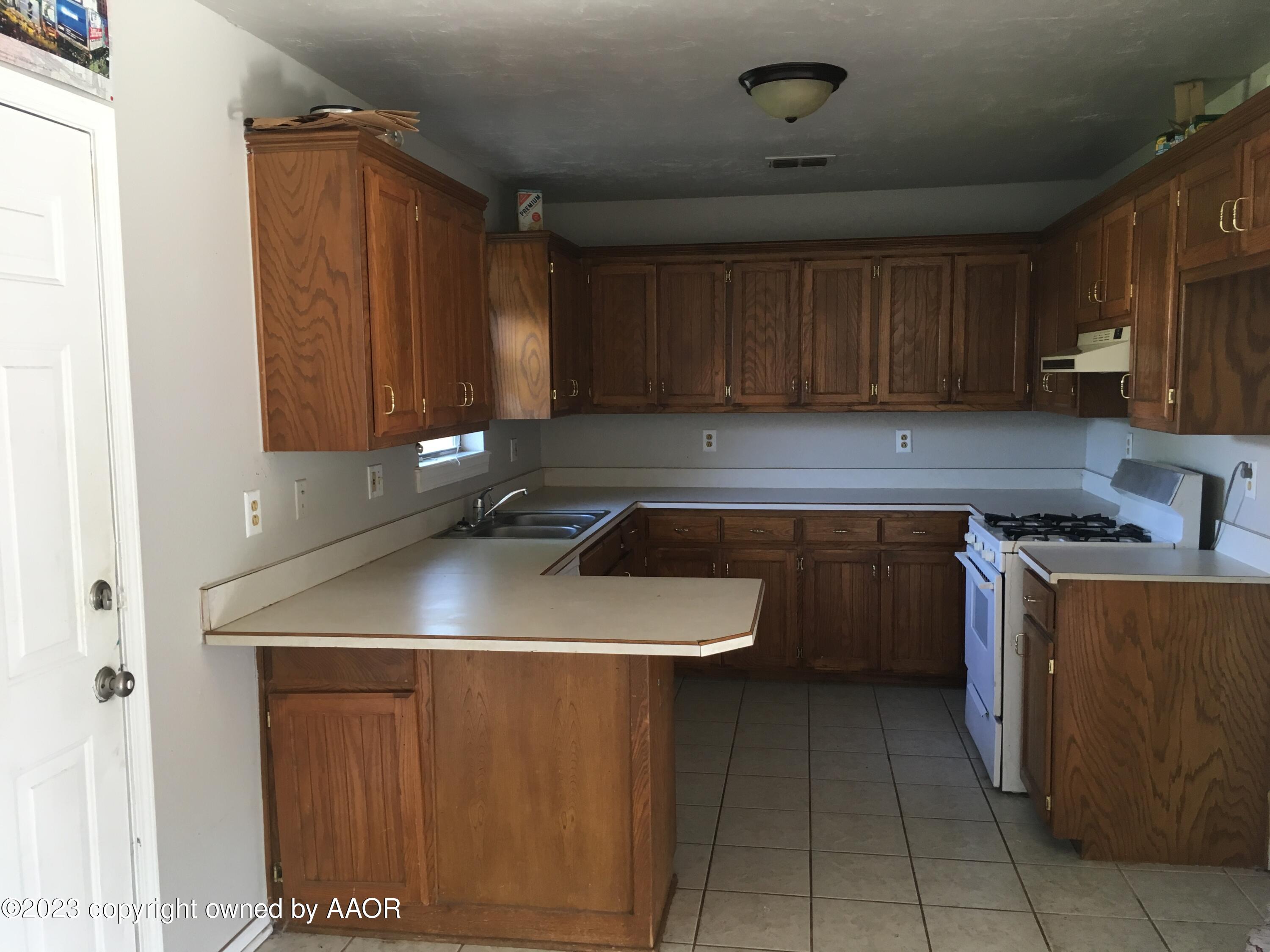 4415 South Hayden Street Amarillo, TX 79110 - Photo 4 of 7 a kitchen with a sink a stove and cabinets