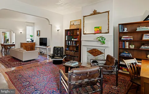 a living room with fireplace furniture and a rug