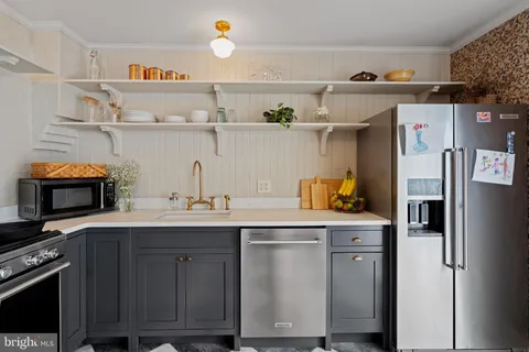 a kitchen with stainless steel appliances granite countertop a sink a stove and wooden cabinets